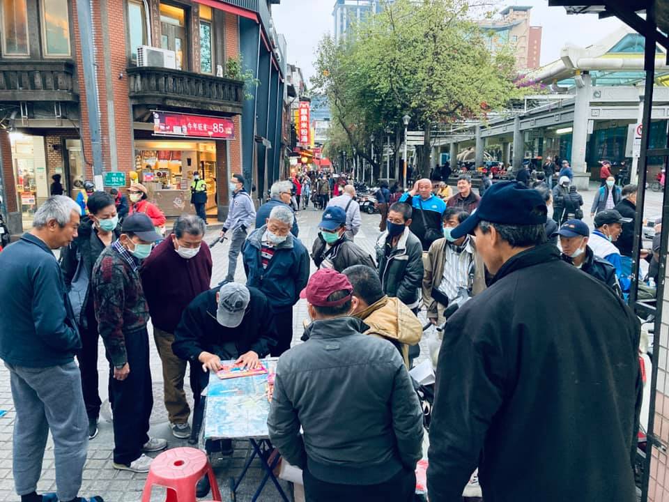 龍山寺附近，聚集再一起圍觀他人玩刮刮樂的長輩們。（source: FB/林 承毅，連結：https://www.facebook.com/photo/?fbid=10224836745853136&set=pcb.10224836733892837）