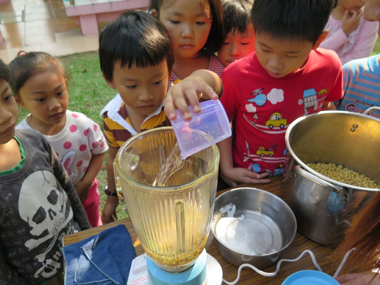 (《在地好豆就醬喝-本土豆漿前進校園》社區集資案中,臺南新化周邊國小孩子們正聚精會神一起磨豆漿,讓動手作成為最直接的食農教育方式)